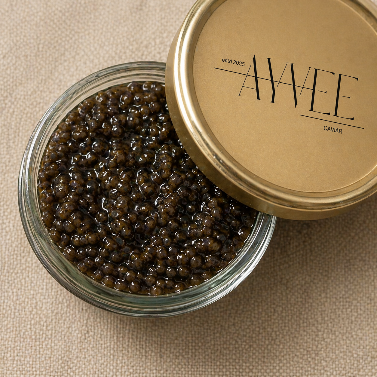 Jar of caviar with a gold lid featuring 'AWEE' branding on a beige background